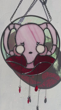 short video of don't ovary act uterus stained glass shown against sunlit white background showing glass refractions