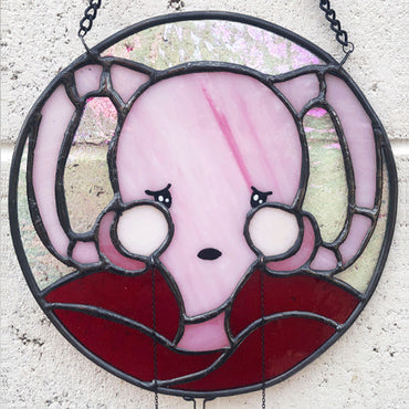 close up of don't ovary act uterus stained glass shown against white brick background 