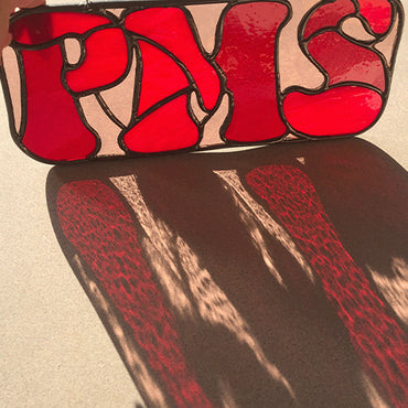 red PMS stained glass sign with sun streaming through showing coloured glass refractions