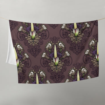 image of 50" x 60" blanket hanging in half on a clothes line to show size with repeated pattern image of a corpse flower with skulls on filigree and dark, smokey, deep purple background