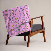 image of 50" x 60" Crystals most Mystical blanket draped over a chair with repeated pattern of rainbow crystals on a pink background