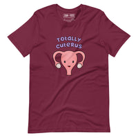 Maroon coloured  t-shirt with an illustration of a cute uterus character smiling with the text in purple 'Totally Cuterus'
