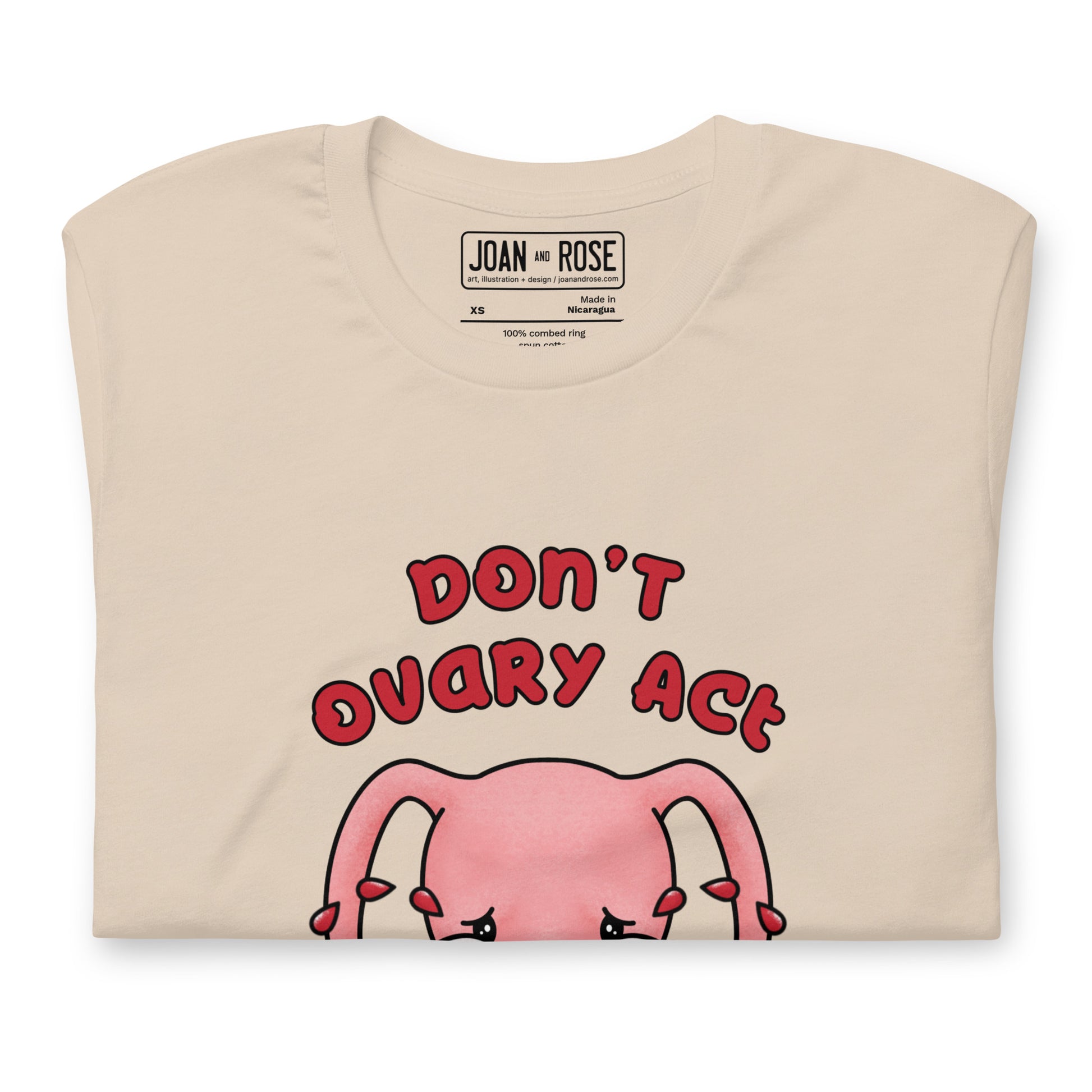 Close up of Don't Ovary Act t-shirt in cream showing inside label details
