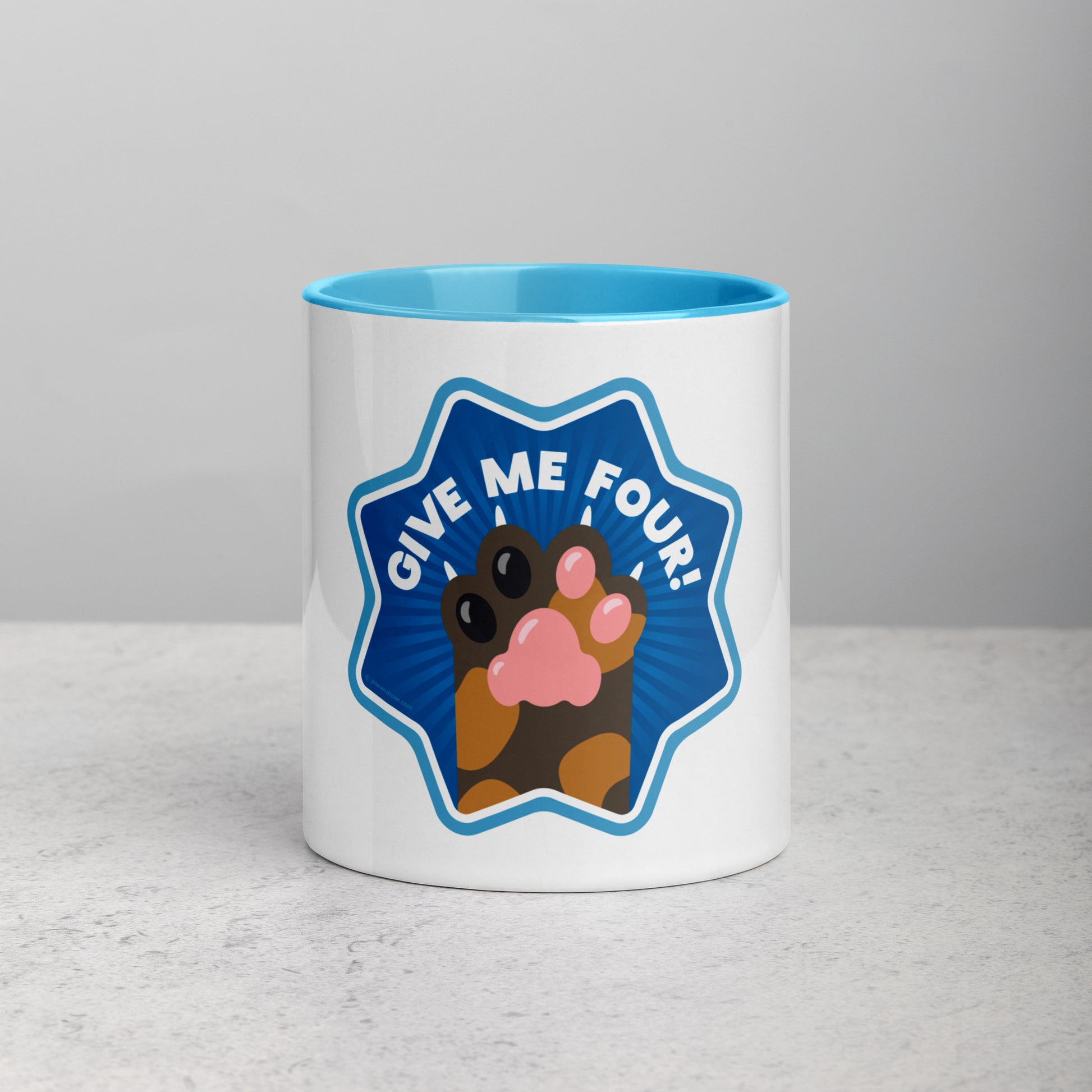 front facing image of a white mug with blue interior and handle. Mug has image of a tortoiseshell cats paw on a blue 8 sided star with the text 'give me four' 