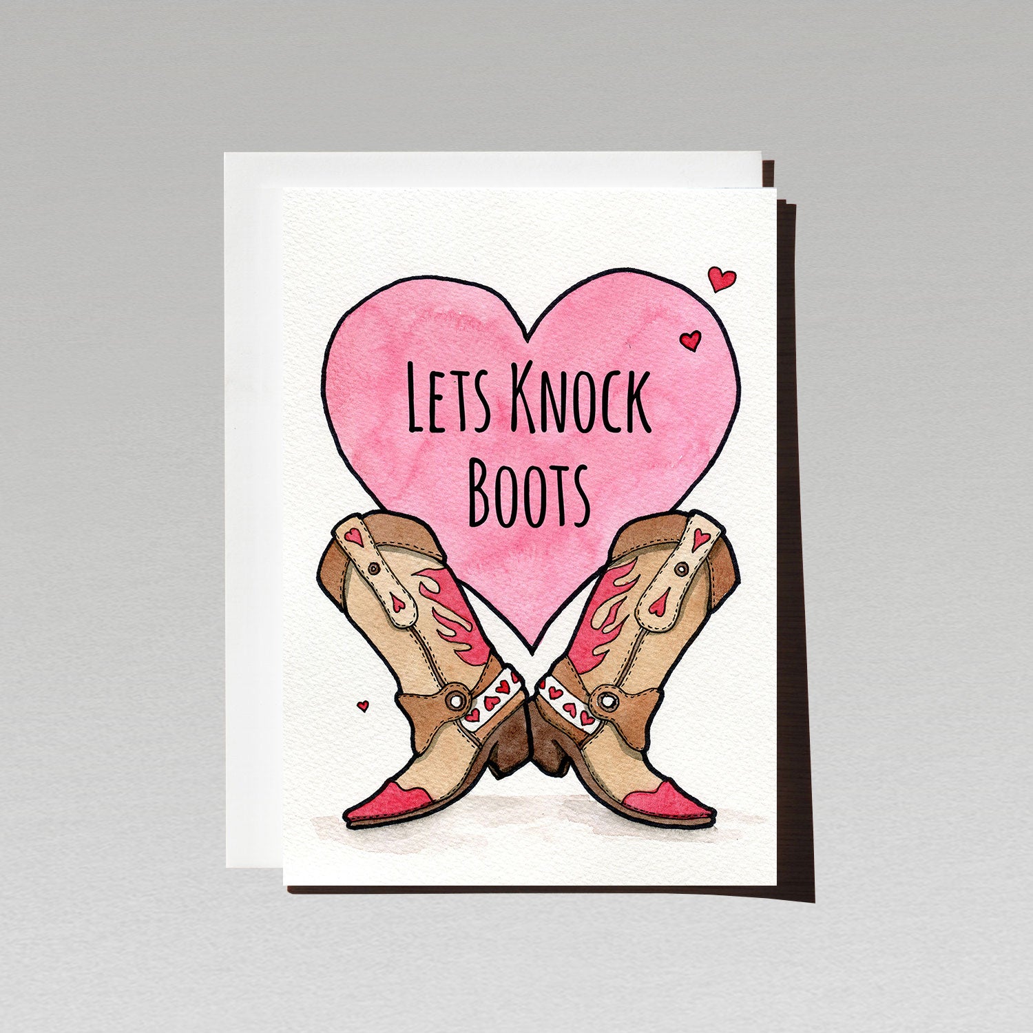 Pair of cowboy boots on a giant pink loveheart on white background with text Lets Knock Boots