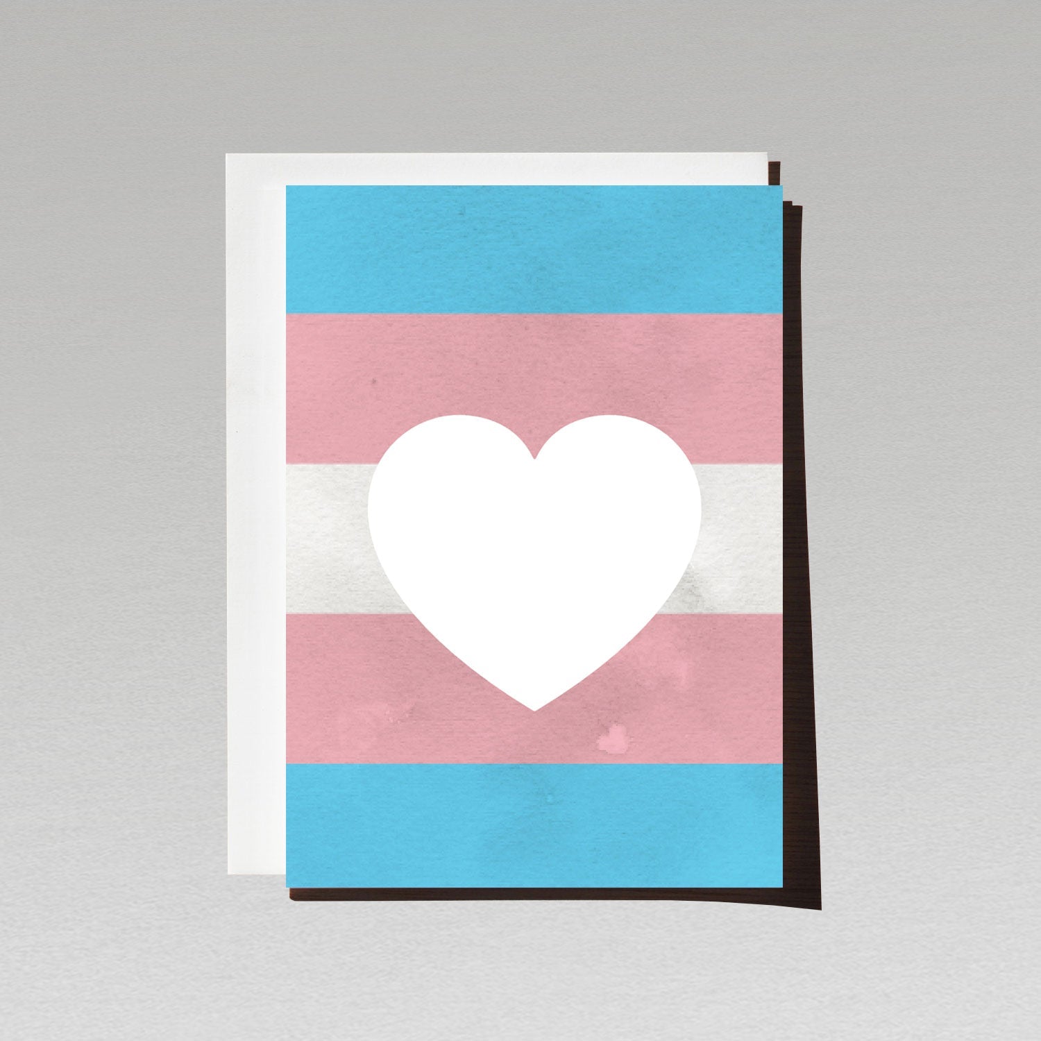 Greeting card with large white love heart sitting on LGBTQI transgender flag background