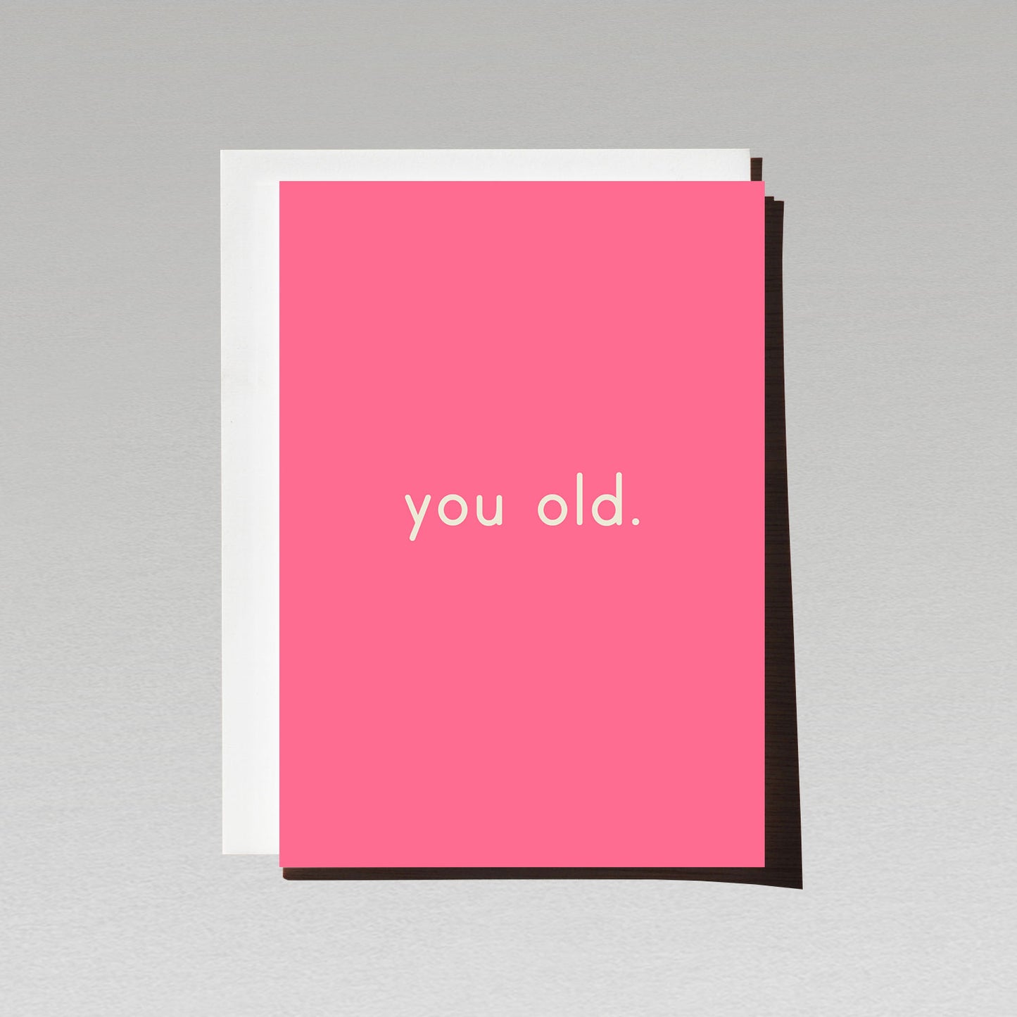 Birthday card with minimalist white text you old. on bright pink background